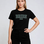 Woman wearing a black t-shirt with 'BRIDE' text on a plain background