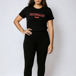 Woman wearing a black t-shirt with text and black leggings on a white background